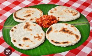 a green plate of food with three pancakes and salsa at HindaHaven in Weligama +25 photos