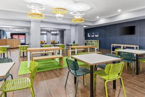a dining room with tables and chairs at Spark by Hilton Cincinnati Fairfield in Forest Park