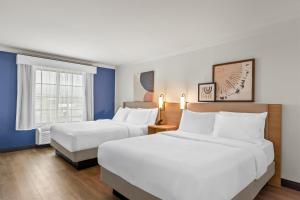 a hotel room with two beds and a window at Spark by Hilton Cincinnati Fairfield in Forest Park +33 photos