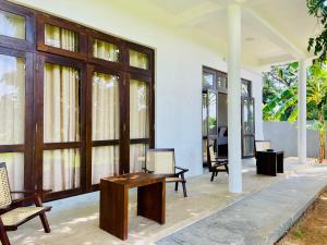 a room with a table and chairs and windows at Ayubowan Yala in Tissamaharama