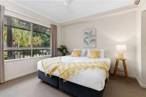 a bedroom with a large bed and a window at Tropical Resort with balcony overlooking pool in Westcourt +14 photos