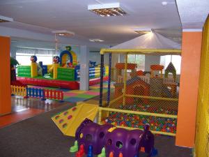 a childrens play room with a playground and a slide at Pretty Apartment in Jelgava