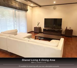a living room with a white couch and a flat screen tv at The Nine Kings in Imabari +47 photos
