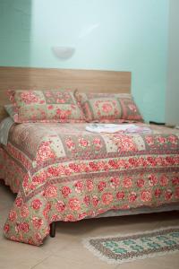 een bed met een rode en witte deken en kussens bij Pousada Theisen in Gramado