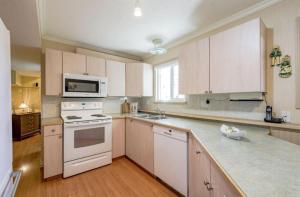 a kitchen with white appliances and white cabinets at Spacious 2 Bedroom Suite in Delta
