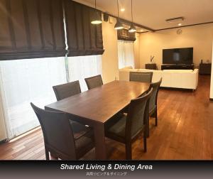 a dining room with a wooden table and chairs at The Nine Kings in Imabari