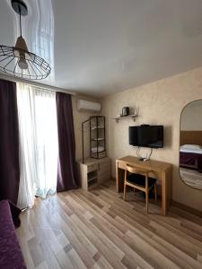 a room with a bed and a desk and a television at Amber Boutique Hotel in Tbilisi City +32 photos