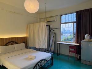 a bedroom with a bed and a large window at arakhouse อารักษ์เฮ้าส์ in Godown