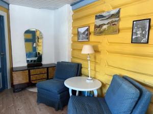 ein Zimmer mit zwei Stühlen, einem Tisch und einem Spiegel in der Unterkunft Sevletunet B&B and Cabins in Rødberg