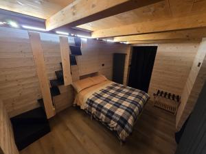 a small bedroom with a bed in a wooden room at Muranche Lofts N1 in Valtournenche