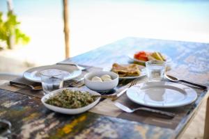 a table with plates and bowls of food on it at Villa Argento in Rimbudu