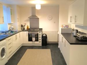 a kitchen with white cabinets and a stove top oven at City Centre Cottage in Inverness