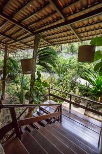 a porch with a pergola and a wooden bench at Hotel Ponta do Madeiro in Pipa