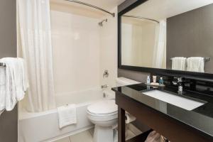 a bathroom with a sink and a toilet and a mirror at Comfort Inn Sherbrooke - Estrie in Sherbrooke +44 photos