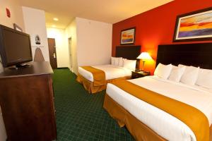 a hotel room with two beds and a flat screen tv at Landmark Inn Fort Irwin in Fort Irwin