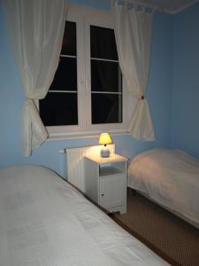 シュクラルスカ・ポレンバにあるApartament Cristalのベッドルーム1室(ベッド2台、ナイトスタンドのランプ付)
