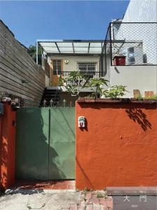 a green and orange gate in front of a building at Light Room in Tainan