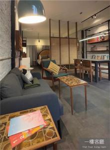 a living room with a blue couch and a table at Light Room in Tainan