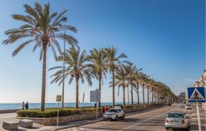 a street lined with palm trees next to the beach at Gorgeous Apartment In Calafell With Swimming Pool in Calafell +12 photos