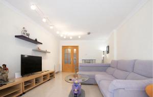 a living room with a blue couch and a tv at Gorgeous Apartment In Calafell With Swimming Pool in Calafell