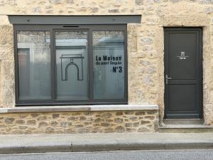a window of a building with a sign in it at L'écrin - Studio Cosy et Lumineux in Andance