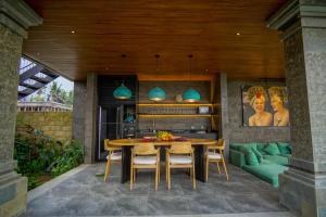 a dining room with a table and a green couch at Ningtaru Villa Ubud in Penginyahan