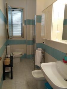 a bathroom with a sink and a toilet and a mirror at Akron B&B in SantʼAlessio Siculo