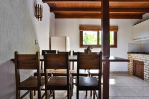 a kitchen and dining room with a table and chairs at Pousada Areias do Rosa in Praia do Rosa
