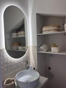 a bathroom with a white sink and a mirror at CharmandView Assisi - vista unica su Basilica di Santa Chiara con terrazza panoramica esclusiva nel centro storico in Assisi