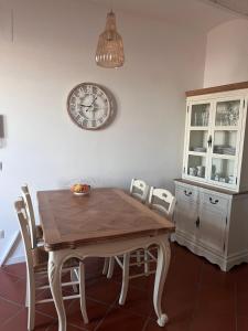 a dining room table with chairs and a clock on the wall at CharmandView Assisi - vista unica su Basilica di Santa Chiara con terrazza panoramica esclusiva nel centro storico in Assisi