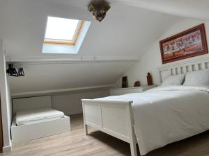 a bedroom with a white bed and a window at Duplex in Escaudain +15 photos