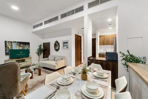a dining room and living room with a table and chairs at FIRST CLASS Villa Peaceful Pool View Retreat in Dubai