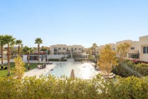a swimming pool in a park with palm trees and buildings at FIRST CLASS Villa Peaceful Pool View Retreat in Dubai