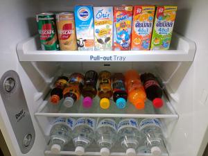 a refrigerator filled with bottles of soda and drinks at Condo I-House Laguna Garden RCA - Behind Sukhumvit Thonglor Asoke Emporium Bangkok Hospital Piyavet Hospital Makkasan Airport Link MRT SKY TRAIN in Bangkok