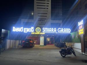 a dealership with a motorcycle parked in a parking lot at Sithara Grand in Ongole +7 photos
