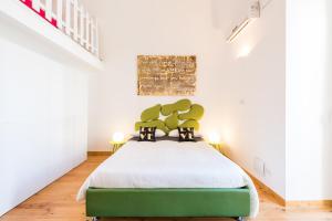um quarto com uma cama verde e paredes brancas em Art Loft M8 Bari City Centre em Bari