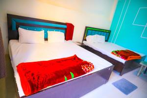 a bedroom with two beds with red and white sheets at Shri ram doot niwas in Ayodhya +8 photos