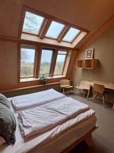 a bedroom with a large bed in front of a window at Bed & Coffee Skilleplaatsje in Den Burg
