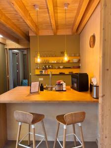 a kitchen with a counter and two stools at Bed & Coffee Skilleplaatsje in Den Burg