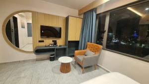 a hotel room with a chair and a desk and a mirror at White Panda hotels Shree Radhe in Dwarka