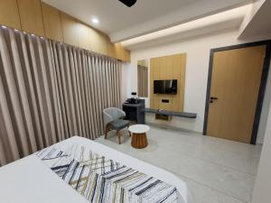 a hotel room with a bed and a chair and a television at White Panda hotels Shree Radhe in Dwarka +34 photos