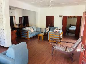 a living room with a couch and chairs and a table at Villa Indeewara in Welipenna East