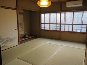 Habitación vacía con puerta y ventana en Murasakino Guesthouse, en Kioto