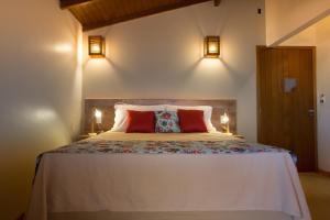 1 dormitorio con 1 cama grande y 2 lámparas en Pousada Areias do Rosa, en Praia do Rosa
