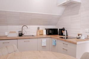 a kitchen with white cabinets and a counter top with a microwave at Apartamenty Pienińska Aura in Czorsztyn