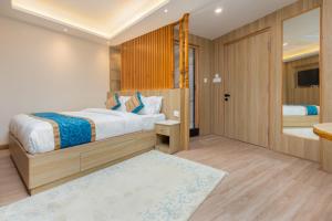 a bedroom with a large bed and a bathroom at Tritara Apartment in Kathmandu