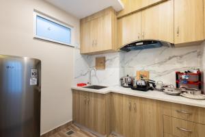 a kitchen with wooden cabinets and a stainless steel refrigerator at Tritara Apartment in Kathmandu