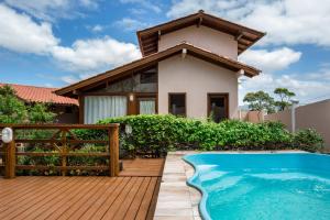 a house with a swimming pool in front of a house at Pousada Areias do Rosa in Praia do Rosa