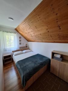 a bedroom with a large bed with a wooden ceiling at Jefimija in Jasikovice