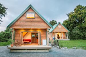 a tiny house with a porch and a patio at Kahere Retreat in Franz Josef